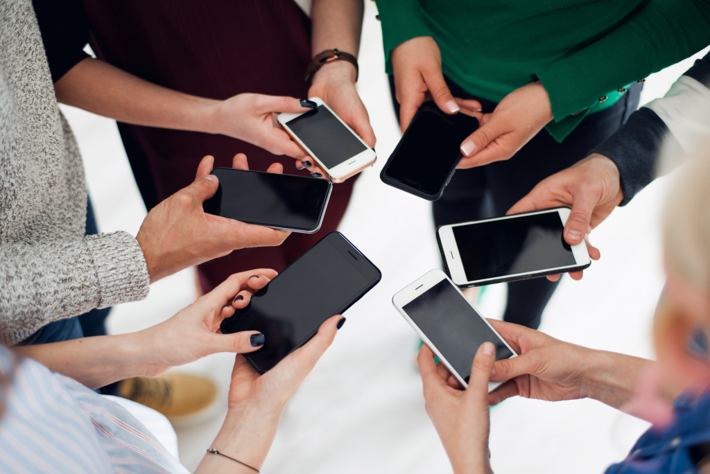 Shot of a group of colleagues using their smartphones in a huddle