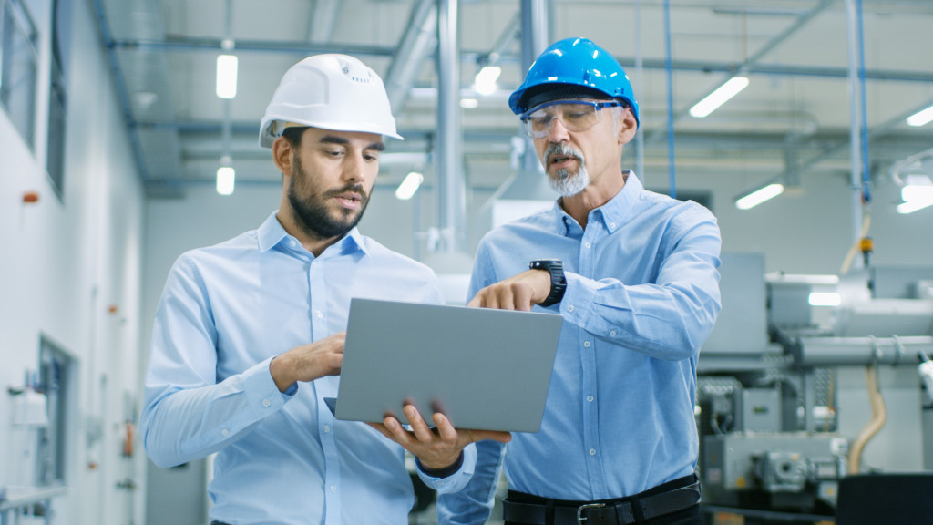 manufacturing businessmen using a laptop in a manufacturing workplace