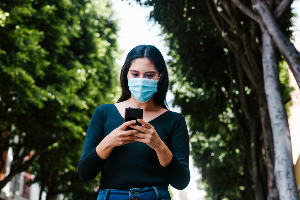 A woman with facemask using her phone